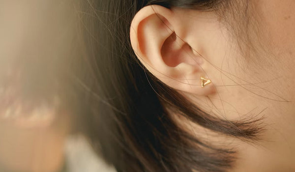 A stylish girl showcasing a delicate stud earring, adding a touch of elegance to her overall look