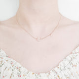 close up shot of neck and collarbone area of female wearing pretty floral top and a dainty gold plated necklace featuring a large moon shaped pendant made up from cubic zircona stones and a smaller star pendant