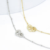 top close up view of two elegant necklaces featuring three detachable round charms in gold and silver