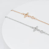 top view of two delicate necklaces featuring a small crossed star pendant and a cubic zirona stone in rose gold and silver